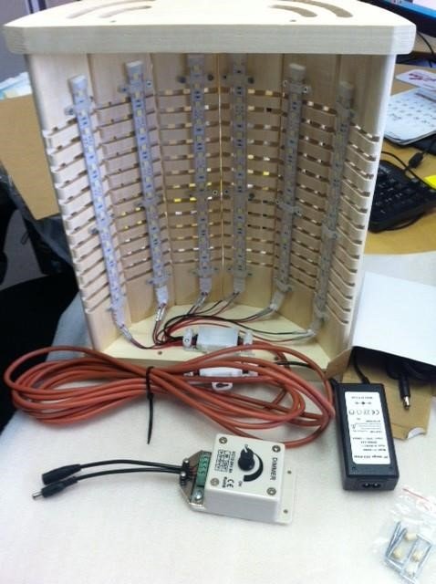 LED-strip monterad på träpanel med dimmer och transformator, projekt för hemmabruk.