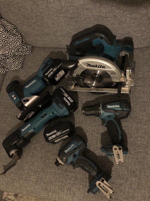 Samling av Makita elverktyg inklusive borrmaskiner, en skruvdragare och en cirkelsåg på ett tygunderlag.