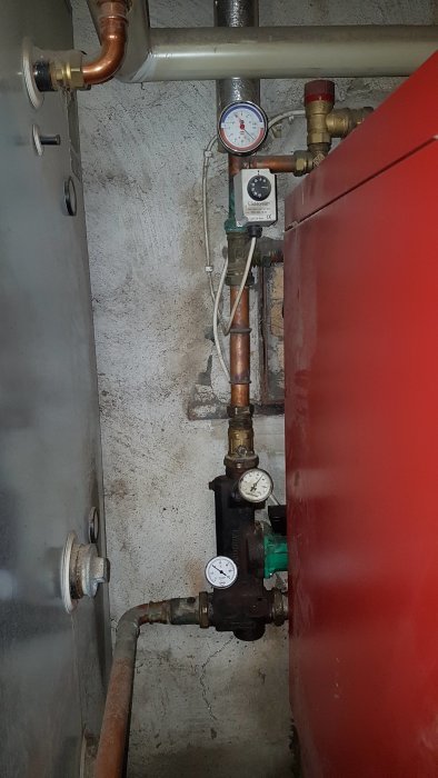 Värmesystem med ackumulatortank, termometrar och tryckmätare, indikerar potentiellt problem.