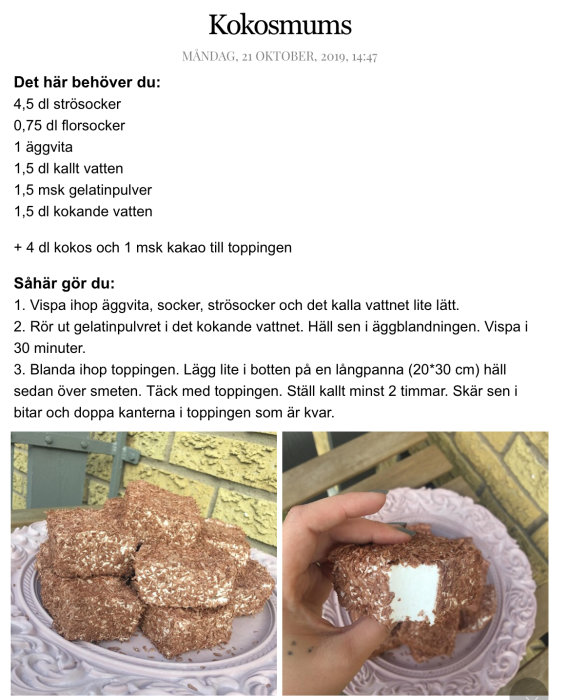 Hand håller en kokosmums med synlig vit fyllning, ett fat med flera kokosmums i bakgrunden.