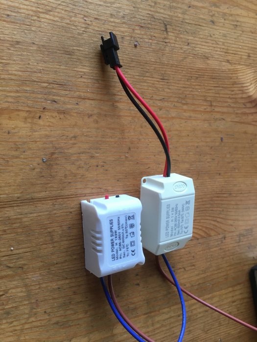 LED-lampors drivdon med anslutna kablar på ett träbord.