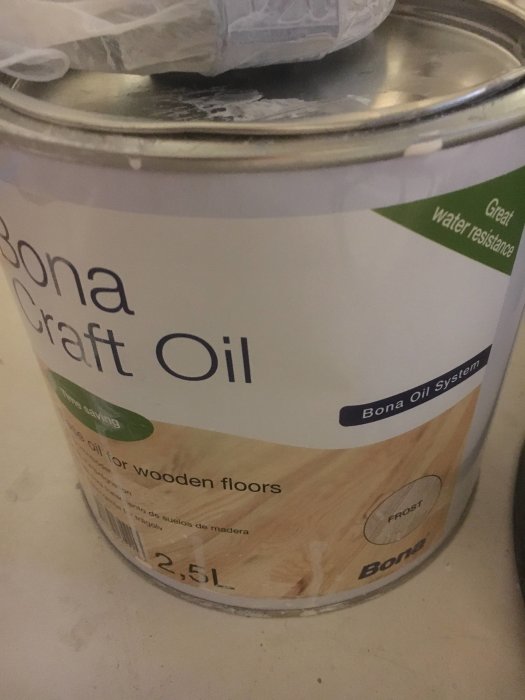 Burk med Bona Craft Oil för trägolv, 2,5 liter, delvis täckt av plast.