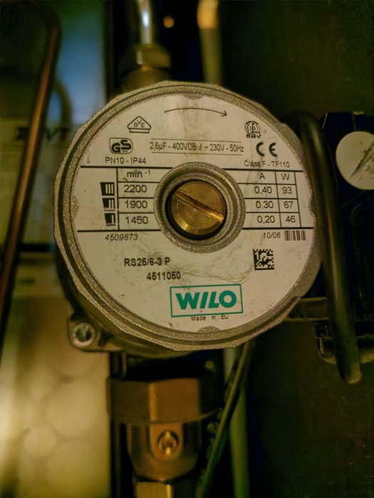 En bild på en Wilo-cirkulationspump med tekniska specifikationer synliga, monterad med sladdar i bakgrunden.