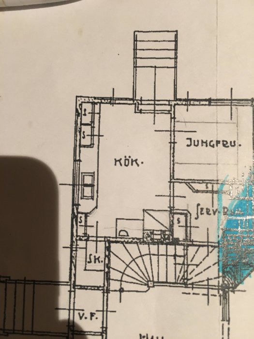 Äldre köksritning med markerad fläktkåpa och oklar text till höger, skugga av en hand syns.