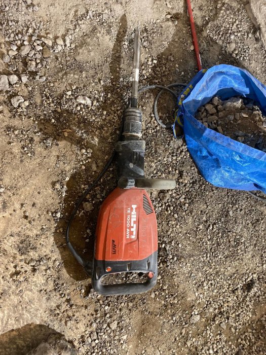 Hilti TE 1000-AVR bilningshammare på ett nedrivet betonggolv med betongrester och blå säck.