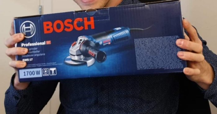 Person håller en oöppnad låda av en BOSCH Professional vinkelslip på 1700 W.