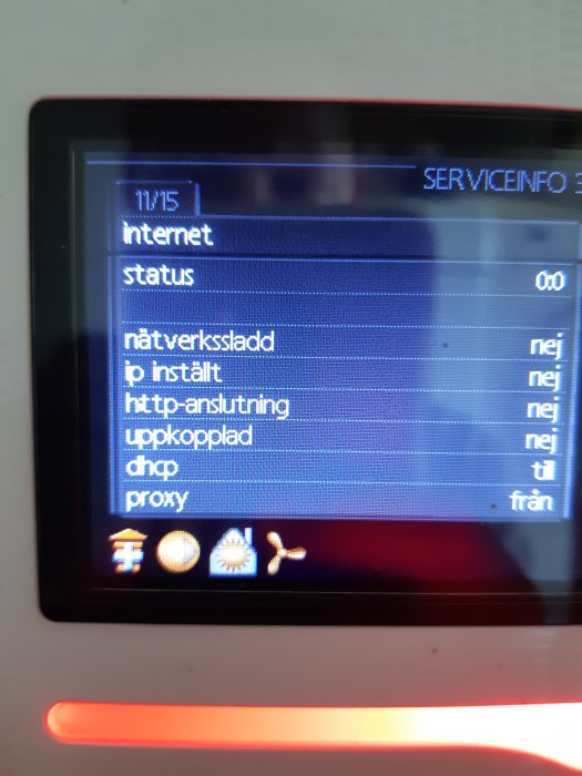 Närbild på display av en värmepump som visar serviceinformation med statusmeddelanden.