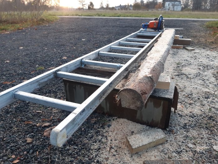 Hembyggd stegsåg för att såga stock med en motorsåg monterad på en släde, konstruerad av aluminiumstege och trä.