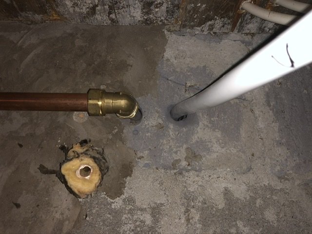 Vatteninstallation med PAL-slang i källarutrymme, rör dragna genom betonggrund.