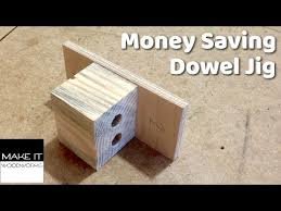 Hemgjord träjigg med hål för att borra pluggar, text "Money Saving Dowel Jig".