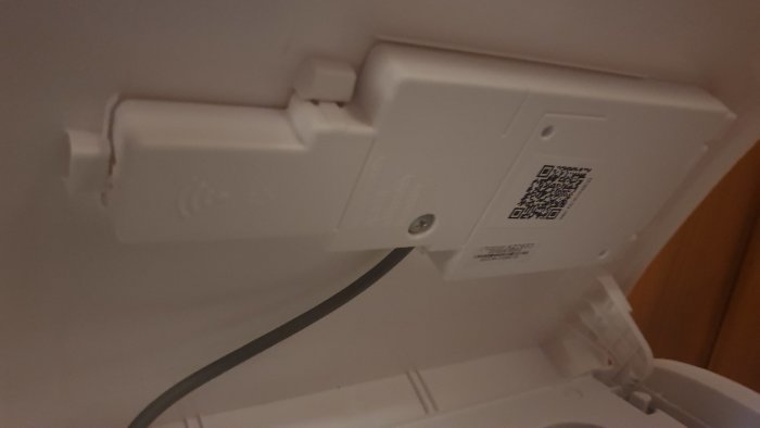 Ny luftvärmepumpmodul med WiFi-tecken och QR-kod, oviss placering för dongel.