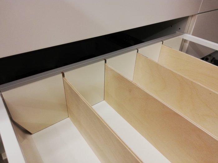 Plywoodlådavdelare i öppen låda av en IKEA-bänk, spontade fronter och iskruvad bakvägg.