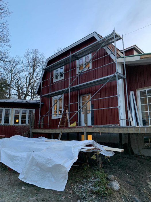 Renovering av rött hus med ställning och skyddsplast, felaktigt överstycke och 10 cm breda fodrar.