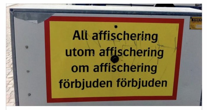 Skylt med skadad text "All affischering utom affischering om affischering förbjuden förbjuden".