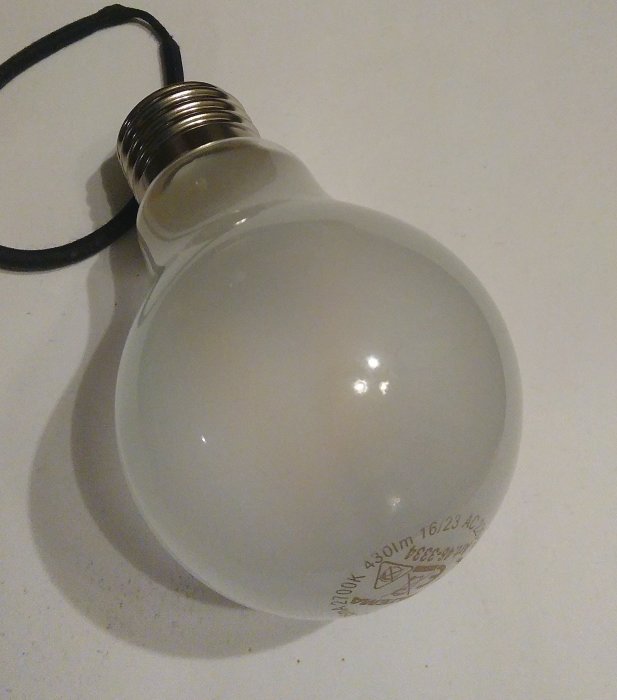 Frostat glas LED-lampa med imiterat glödlampsutseende från Biltema på vit bakgrund.