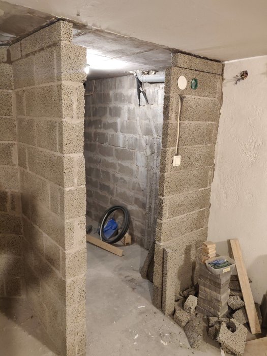Murrade lecablock i källare som formar en dörröppning med en horisontell minibalk överst.