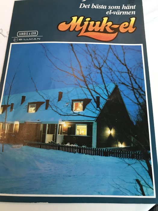 Reklamblad från 1982 för "Mjuk-el" system med bild av radhus i vinterlandskap på kvällen.