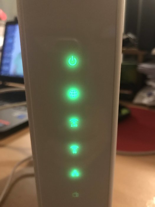 Router med lysande indikatorer för ström, internetanslutning och Wi-Fi-signaler.