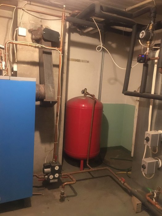 Ackumulatortank och rörsystem i ett pannrum, relaterat till frågan om uppvärmningsproblem.