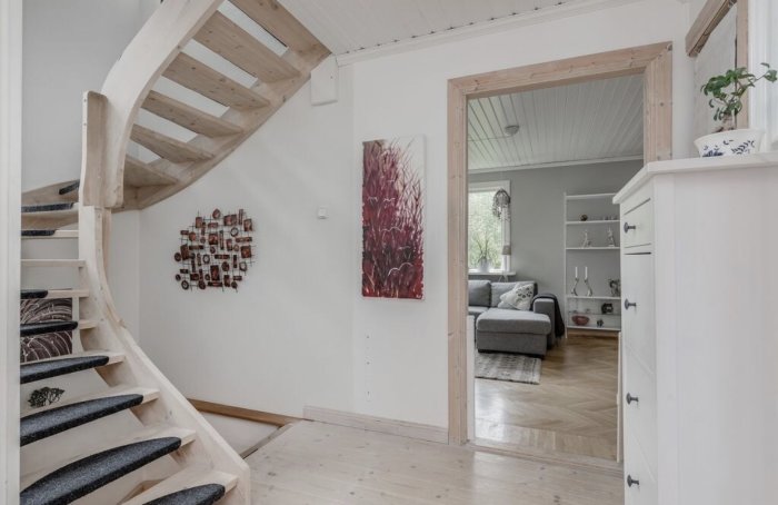 Trappa i hus med öppna steg och plats för trappräcke på höger sida.