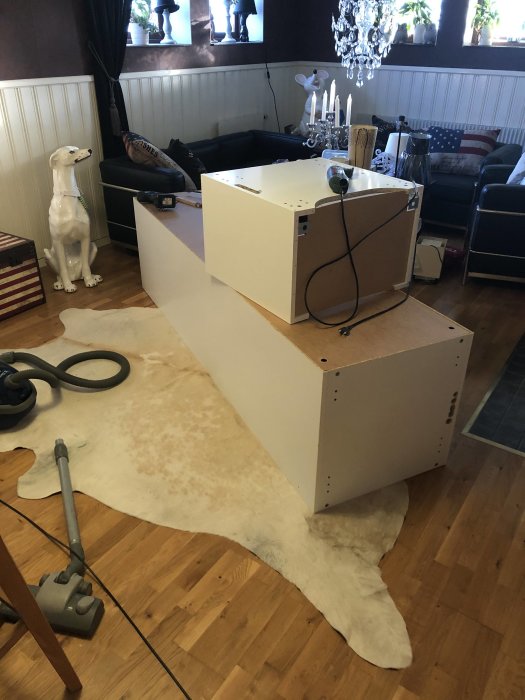 Frys ligger på sidan i ett vardagsrum med verktyg bredvid, under installation eller reparation.