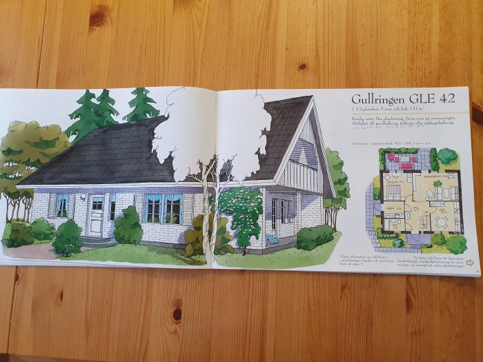 Illustration och planritning av ett enplanshus, Gullringen GLE 42, i en byggkatalog öppnad på ett träbord.
