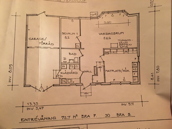 Orginalritning av en entreplan med markerade rum som garage, sovrum, bad, klävård och vardagsrum samt kök/matsal.