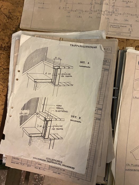 Husritningar för trappanslutning med detaljillustrationer, på ett bord under besiktning.