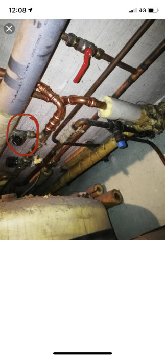 Ventil inringad bland rörledningar och isolering, misstänkt för påfyllning.