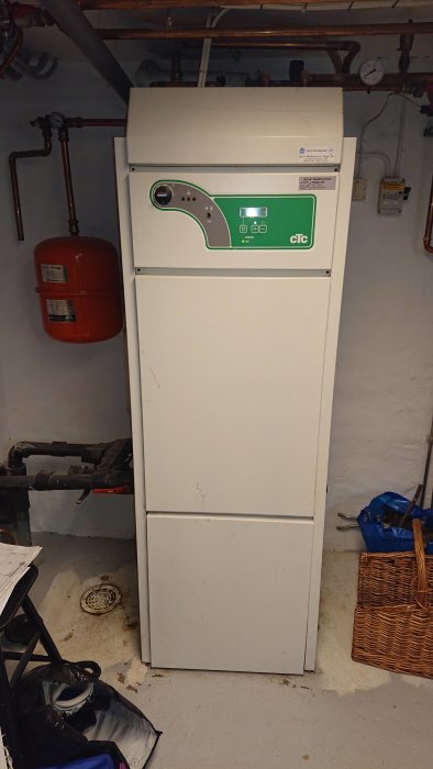 En CTC Ecoheat 4.7 värmepump i ett pannrum med synliga rör och exp.kärl.