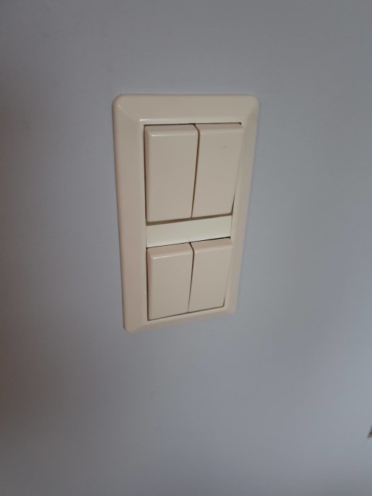 Ivory triple light switch installed on a pale blue wall, possibly seeking a replacement or cover.