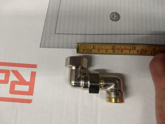 Mätmått som visar dimensionerna på en vinkelrörkoppling mot en griddad bakgrund.