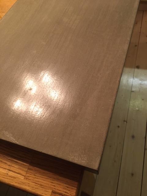 Polerad och lackad industrispackel-fönsterbräda avbildad i närbild med trägolv i bakgrunden.