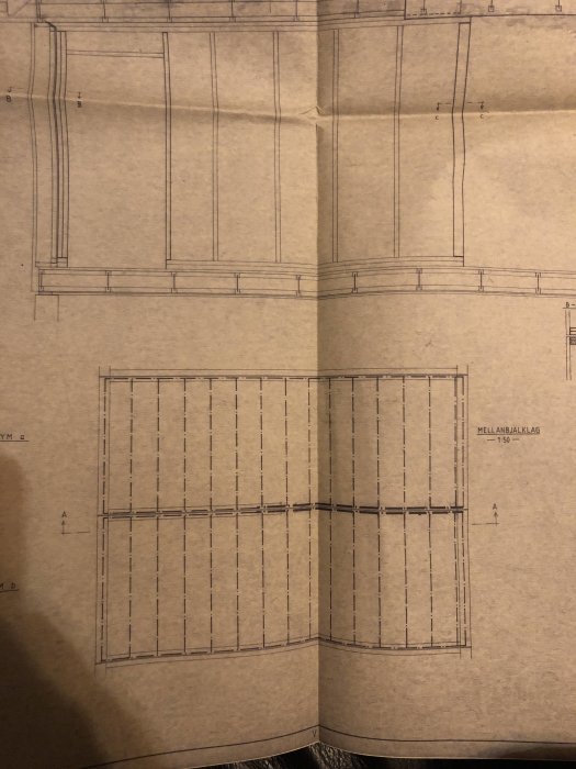 Arkitektonisk ritning av en byggnads bjälklag på brunt papper.