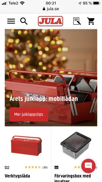 Röd verktygslåda med texten "Årets julklapp: mobillådan" framför en suddig julgran.