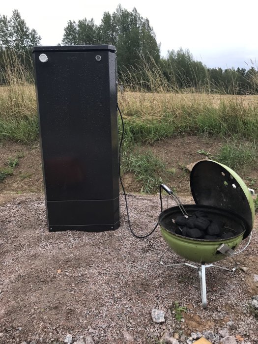 Markmätarskåp från Garo bredvid en kolgrill på en nyanlagd tomt.