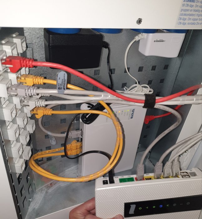 Mediakonverterare med röd fiberkabel och flera nätverksportar i ett serverrum.