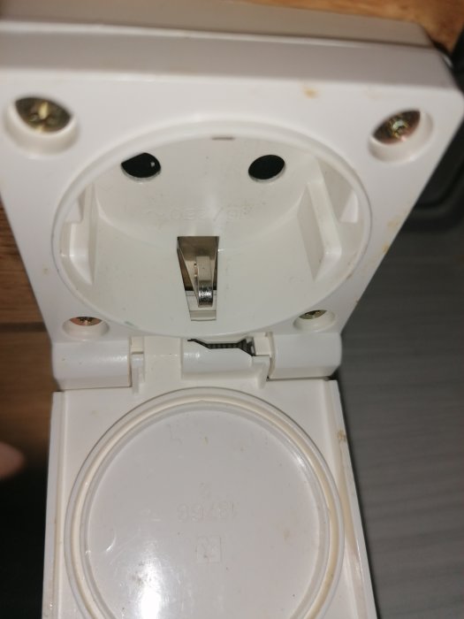 Närbild på en öppen vit eluttag ovanför en badrumsspegel redo för installation av LED-tejp.