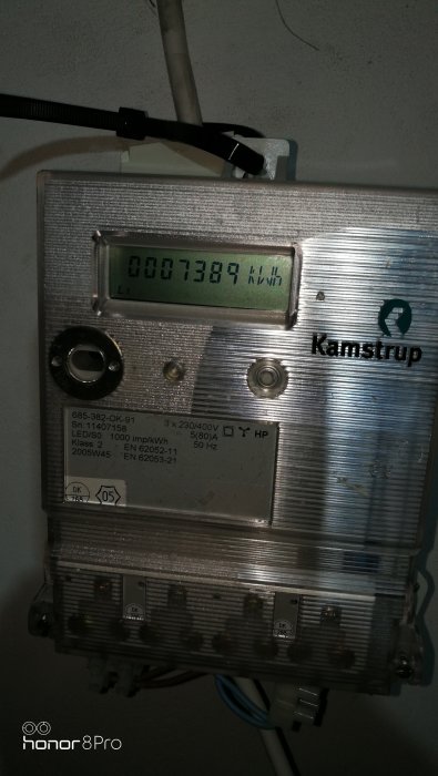 Elmätare från Kamstrup med displayvisning 7389 kWh, monterad på vägg.
