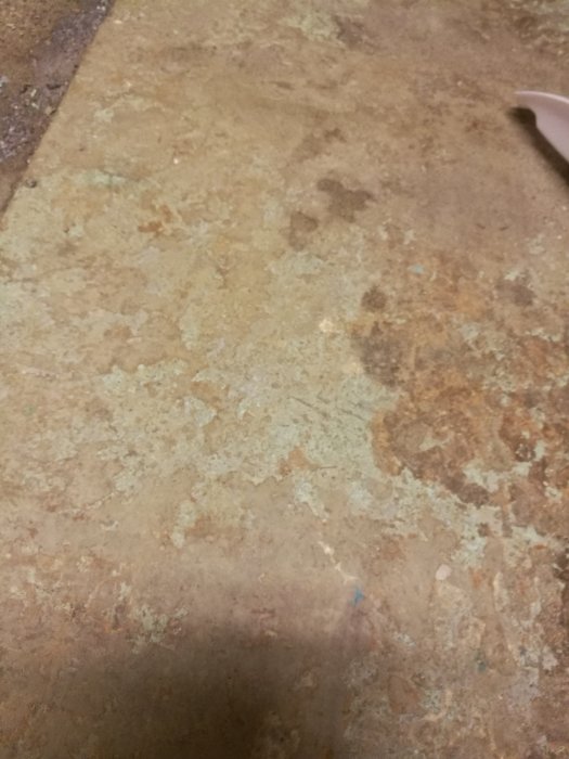Golv med rester av gammal färg och fix, behövande renovering efter stambyte.