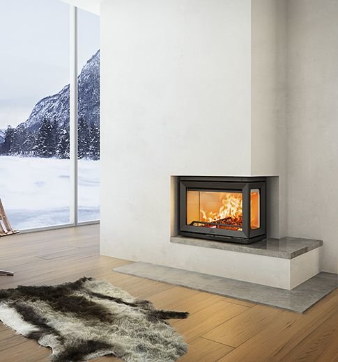 Modern öppen spis i minimalistiskt vardagsrum med stort fönster med utsikt över snöigt bergslandskap.