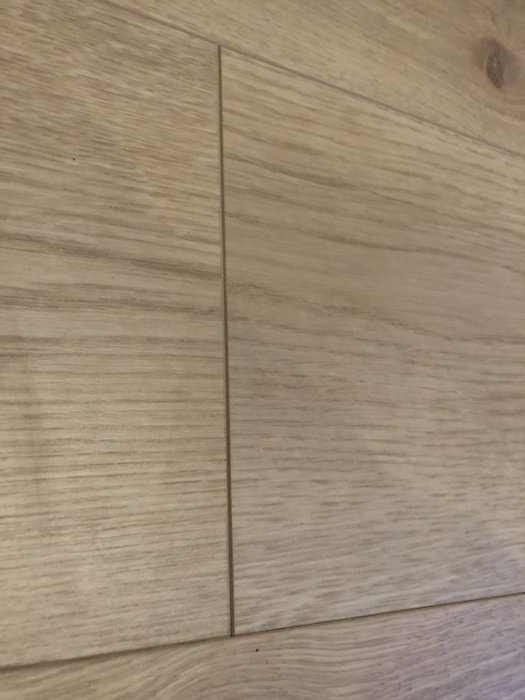 Golv med träbrädor där två brädor inte möts korrekt och lämnar en synlig springa.