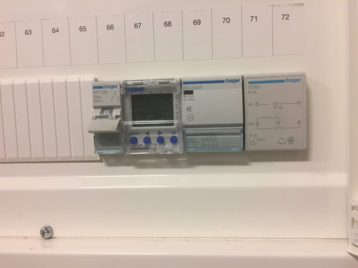 Elektriskt astrour och kontaktorer monterade på en vit vägg, används för utomhusbelysning.