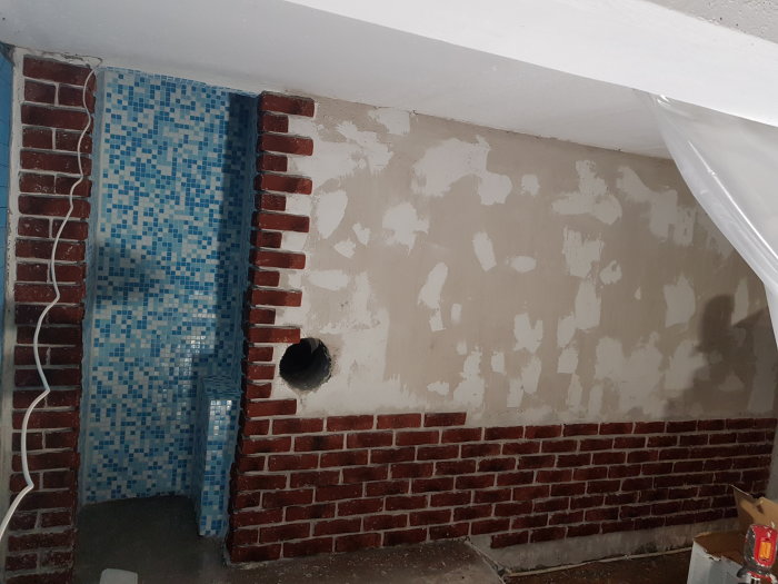 Renoveringsprojekt med ojämna lager fix på vägg, delvis plattlagd med mosaik och dekorsten i halvförband.