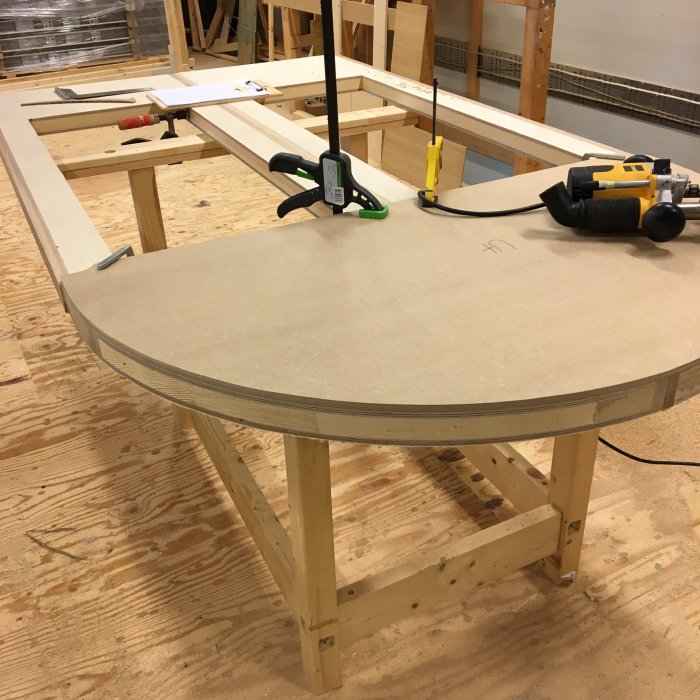MDF-mall fäst på arbetsbänk med klyvor, verktyg och fräs tillverkar del till gårdsdörr.