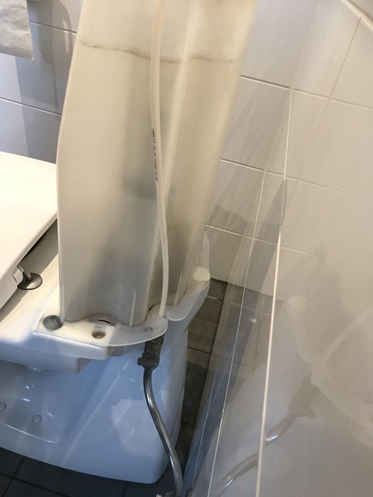 Ifö Sign toalett som läcker från cisternen efter spolning, med synligt vatten på golvet.
