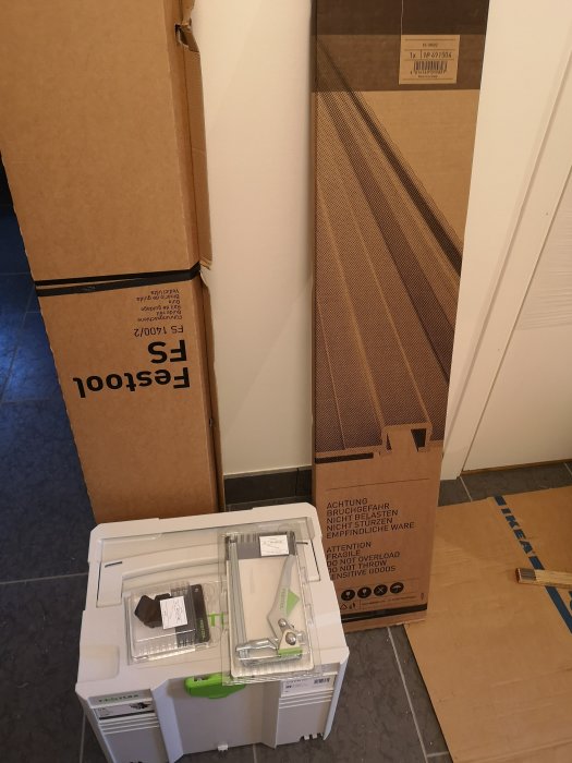 Festool Ts55 REBQ såg, rekylstopp och en tving med skensystem FS 1400 och FS 1080 i förpackningar på golv.