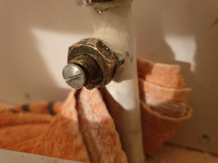 Närbild av en otydlig storlek på en metallventil med en handduk i bakgrunden.