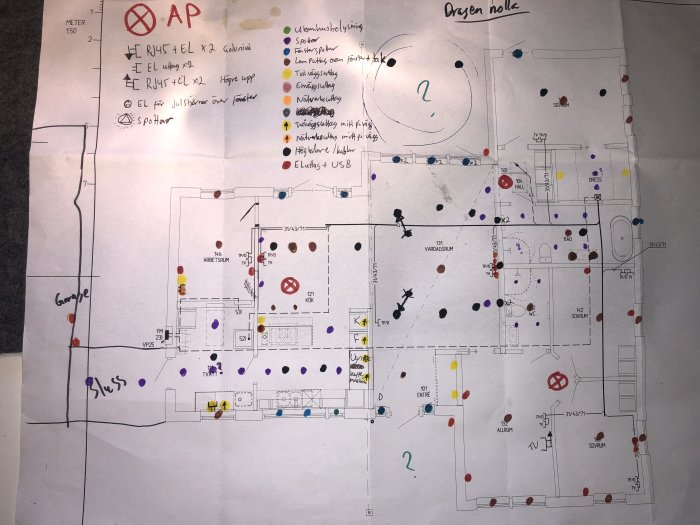 Kluddig handritad planritning av hus med markeringar för elektriska installationer som uttag och spottar.