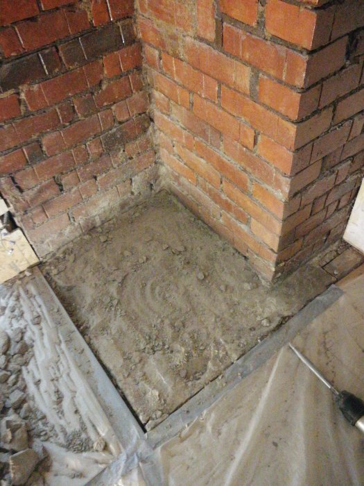 Stenplatta vidrörd av bilning med omgivande tegelmurar och golvspånskivorna nära i rummet.